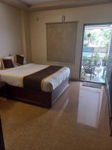 a bedroom with a bed and a sliding glass door at Bhimas Residency in Kurmannapalem
