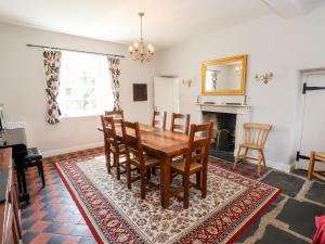 a dining room with a table and chairs and a fireplace at Robin Cottage in Troutbeck
