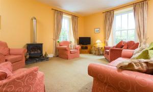 a living room with pink furniture and a fireplace at Hawkshead Hall in Hawkshead