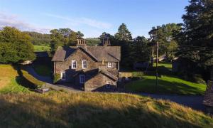 an old stone house in the middle of a field at Hawkshead Hall in Hawkshead