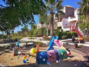 a playground with a toy in the sand in front of a house at Apartment in the middle of nature in Santa Cruz de Tenerife in San Miguel de Abona