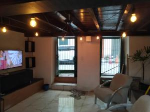 a living room with a tv and chairs and windows at No coração do Pelourinho, perto de tudo. in Salvador