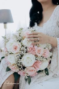 a woman holding a bouquet of pink and white roses at SOFIATEL Rooms in Santa Maria
