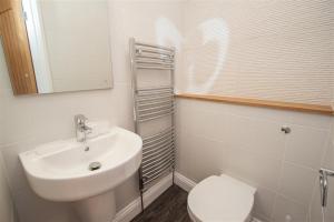 uma casa de banho branca com um lavatório e um WC em Gable End em Keswick