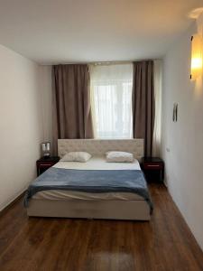 a bedroom with a large bed and a window at Bucharest Residence in Bucharest