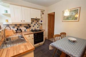 a kitchen with a sink and a table with a tableablish at Briardale Cottage in Ambleside