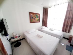 a hotel room with two beds and a television at SOFIATEL Rooms in Santa Maria