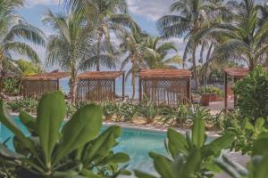un complejo con piscina y palmeras en Maria Del Mar Tulum - Adults Only en Tulum