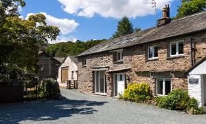 a group of stone cottages on a road at Underhowe in Grasmere