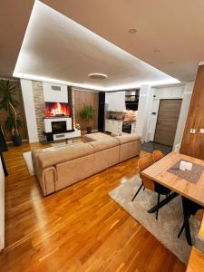 a living room with a couch and a table at Inverno Apartments Bjelašnica in Bjelašnica