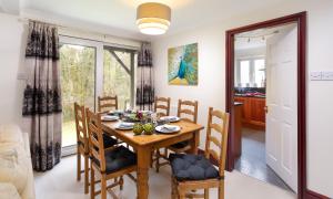 cocina y comedor con mesa de madera y sillas en Beech View, en Ambleside