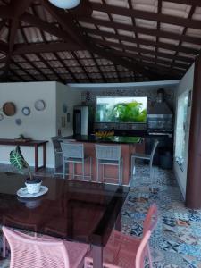 Apartamento em guarajuba 200m da praia في كامساري: مطبخ مع طاولة وكراسي في غرفة