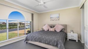 a bedroom with a bed and a large window at Emerald Escape Lighthouse Beach in Port Macquarie
