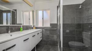 a bathroom with a shower and a sink and a toilet at Emerald Escape Lighthouse Beach in Port Macquarie