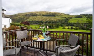 a table and chairs on a balcony with a view at Pennys Cottage in Troutbeck