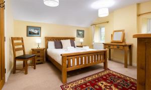 a bedroom with a bed and a chair and a mirror at Cherry Garth in Patterdale