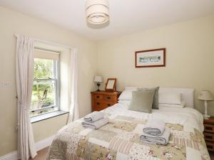 a bedroom with a bed with towels on it at The Mews in Ambleside