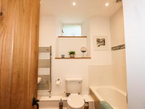 a bathroom with a toilet and a tub and a sink at The Mews in Ambleside
