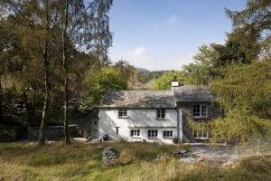 una casa blanca en medio de un campo en Wythebank, en Ambleside
