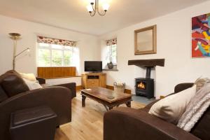 a living room with a couch and a table and a fireplace at Wythebank in Ambleside