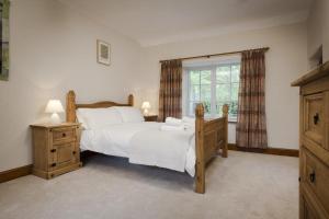 um quarto com uma cama grande e uma janela em Wythebank em Ambleside