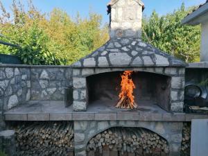 an outdoor pizza oven with fire in it at Apartment Njivice 5320b in Njivice