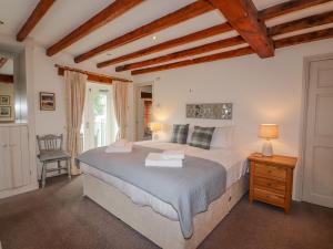 Glen View Cottage في آمبيلسايد: غرفة نوم بسرير كبير وكرسي