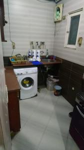 uma cozinha com um lavatório e uma máquina de lavar roupa em الهرم no Cairo