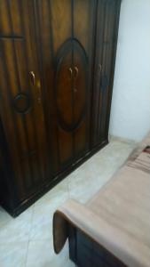 1 dormitorio con armario de madera y cama en الهرم en El Cairo