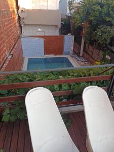 a pair of chairs on a balcony with a swimming pool at Departamentos Temporarios Aeropuerto in Formosa