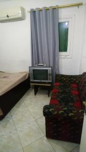 uma sala de estar com uma televisão e um sofá em الهرم no Cairo