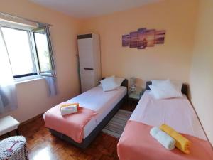 two beds in a room with two windows at Apartments with a parking space Njivice, Krk - 5320 in Njivice