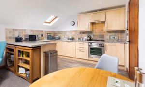 a kitchen with wooden cabinets and a wooden table at High Dow Crag in Coniston