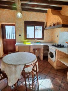 a kitchen with a table and a sink and a stove at El Corchuelo in Corteconcepción