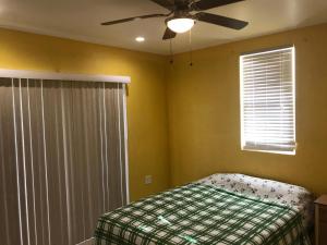 a bedroom with a bed and a ceiling fan at palmvillo master suit 