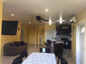 a living room with a table and a ceiling fan at palmvillo master suit 