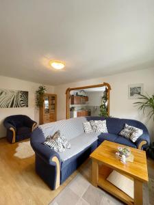 uma sala de estar com um sofá azul e uma mesa em Krásný apartmán v bráně Lužických hor em Cvikov