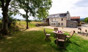 una mesa y sillas frente a una casa en Scalegill House, en Cockermouth