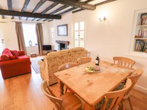 a living room with a wooden table and a couch at Weir Cottage in Ambleside