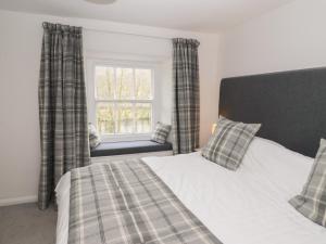 Schlafzimmer mit einem Bett und einem Fenster in der Unterkunft Weir Cottage in Ambleside