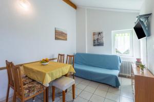 ein Wohnzimmer mit einem Tisch und einem blauen Sofa in der Unterkunft Apartment Karigador 2534b in Karigador