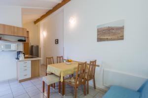 a kitchen and dining room with a table and chairs at Apartment Karigador 2534b in Karigador