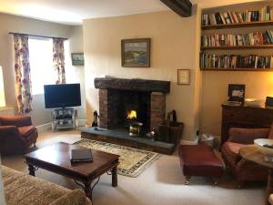 a living room with a fireplace and a tv at White Lion Cottage in Chapel Stile