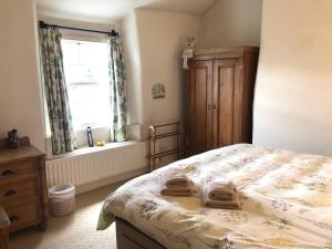 a bedroom with a bed with two towels on it at White Lion Cottage in Chapel Stile