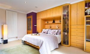 una camera con un grande letto e armadi in legno di The Gallery ad Ambleside