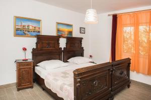een slaapkamer met een groot houten bed en een raam bij Family friendly house with a swimming pool Cista Velika, Vodice - 20234 in Velika Čista