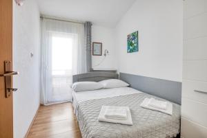 - une chambre avec un lit et 2 serviettes dans l'établissement Apartments by the sea Rogoznica - 2895, à Rogoznica