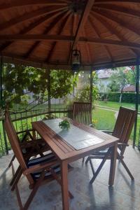 un tavolo e sedie in legno sotto un ombrellone di legno di Apartments with a parking space Otocac, Velebit - 20246 a Otočac