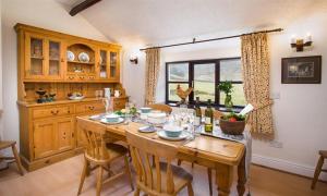 a kitchen with a wooden table with chairs and a dining room at Thirlmere Cottage in Keswick