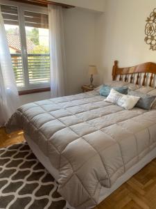 a large bed in a bedroom with a window at Alberdi Centro in Tandil